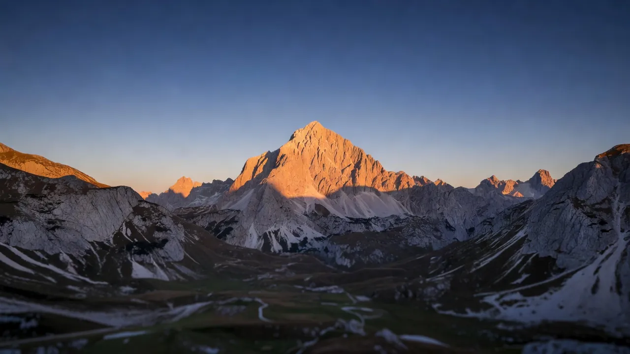 Un randonneur observe les reliefs escarpés des Alpes juliennes, entre crêtes rocheuses et itinéraires de haute montagne.